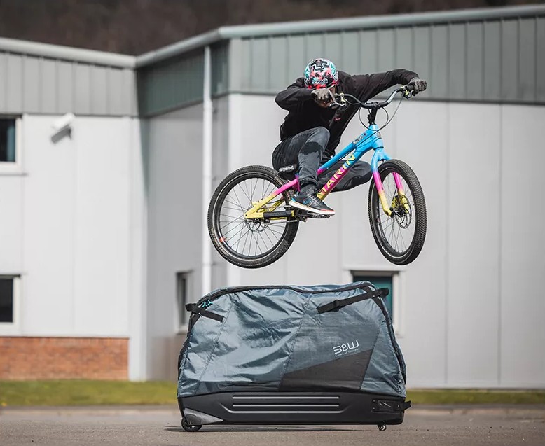 Trial-Biker Duncan Shaw springt mit dem Fahrrad über die aufrecht stehende Bike Bag 2.0 Hybrid 306 von B&W International.